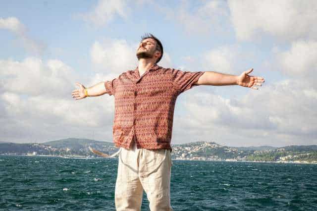 Mentale Wachheit durch kaltes Duschen Man steht mit offenen Armen da