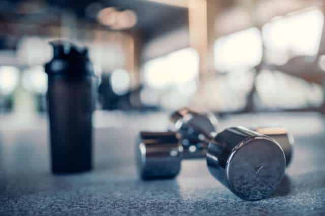 Kraftsport im Alltag integrieren Hanteln liegen auf dem Boden