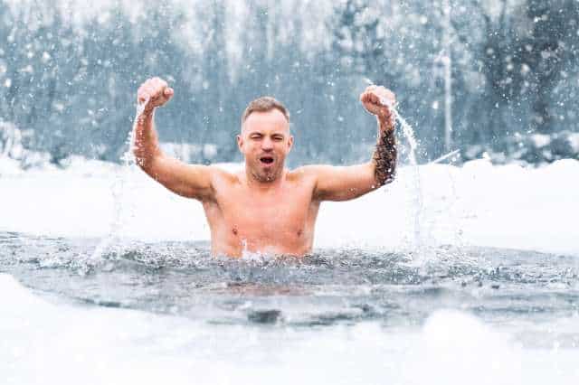 Durch Kältereize aktiver Zustand Mann steht im eiskalten Wasser und wirkt aktiv