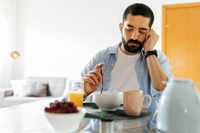 männliche hormone im körper Mann sitzt nachdenklich am Esstisch