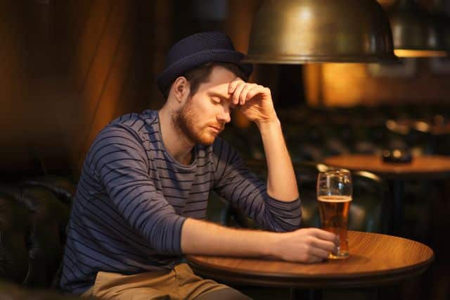 Niedriger Progesteronwert beim Mann Mann sitzt nachdenklich am Tisch